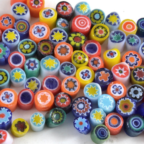 A collection of colorful assorted opaque millefiori glass pieces with various floral and geometric patterns.
